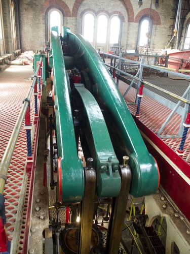 Looking down on a three-part green beam sinking into the floor.