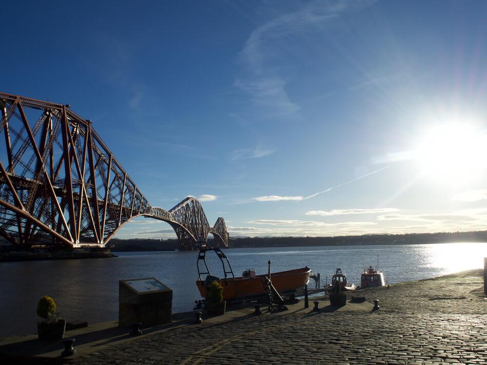 The bridge dominating the background, with the jetty and a few boats in the foreground.